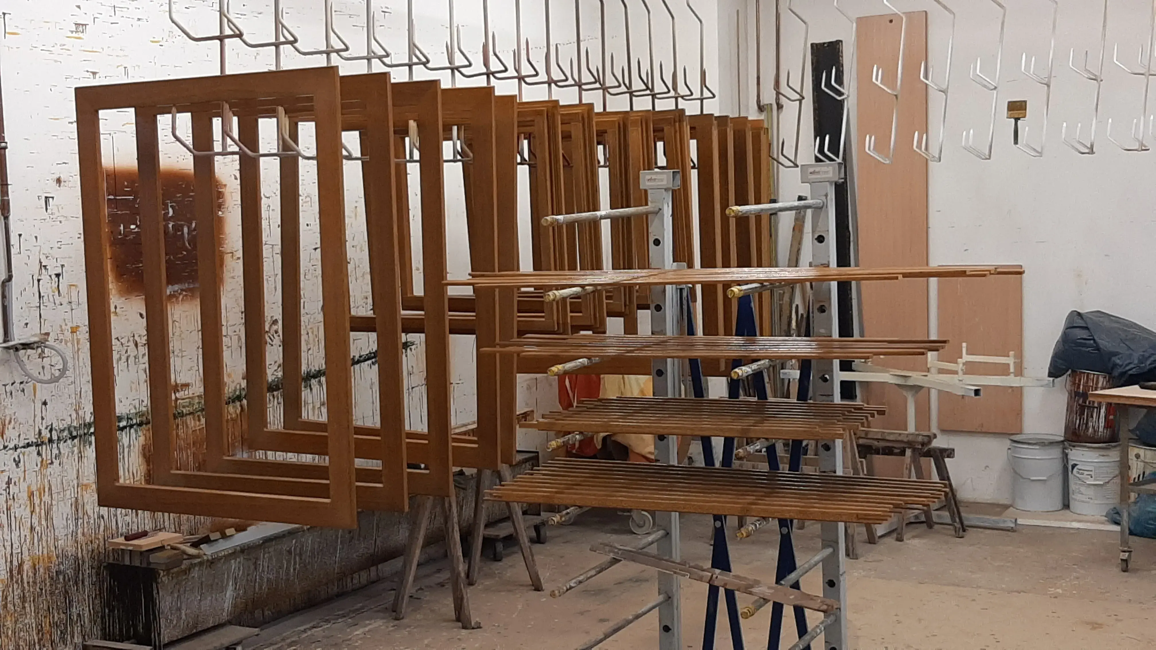 Holzrahmen und Bretter hängen zum Trocknen in einer Werkstatt.